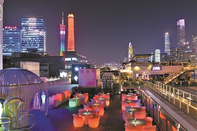 夜幕降臨,位於珠江邊上的琶醍某商家即將開門迎客,遠處是亮燈的廣州塔。